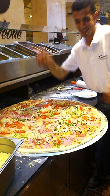 Koch bereitet eine Riesen-Pizza an der Theke vor