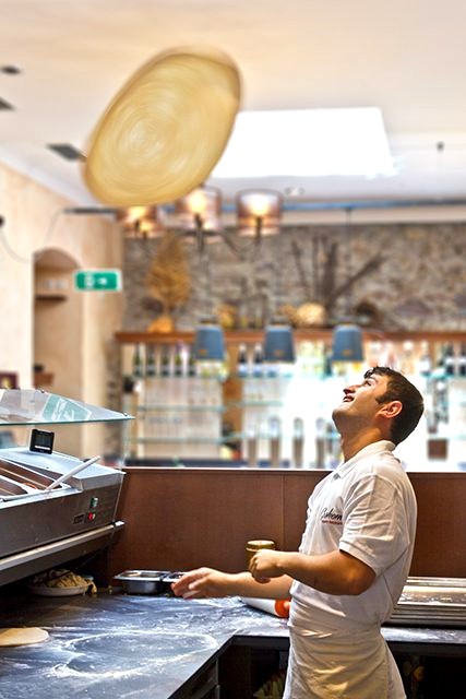 Pizzaiolo wirft den Teig an der Bar